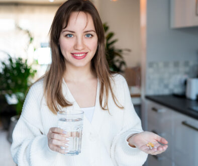 Woman in Her Kitchen Taking Supplements for Health