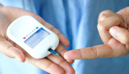 A Woman Holding a Glucose Meter Preparing To Check Her Blood Sugar Type 1 vs Type 2 Diabetes