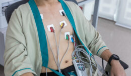 Man Sitting in a Chair Wearing a Holter Monitor Test