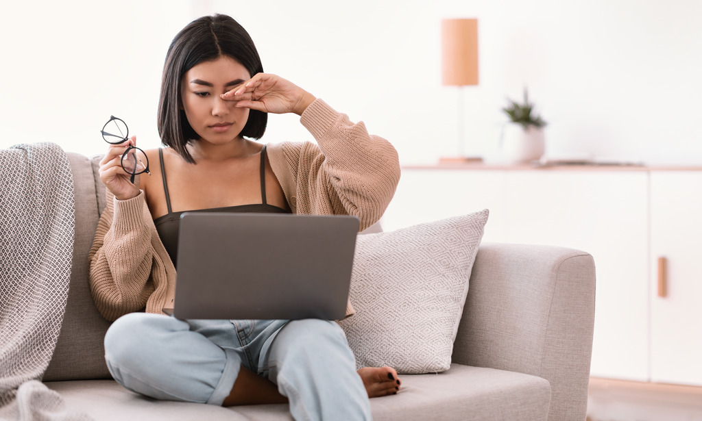 A Young Hispanic Woman Fatigued Sitting on a Couch Rubbing Her Eyes While Looking at a Laptop Warning Signs of Diabetes