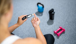 Closeup Of A Woman Checking Her Blood Sugar During Exercise With Workout Equipment In The Background Safe Exercise For Diabetics
